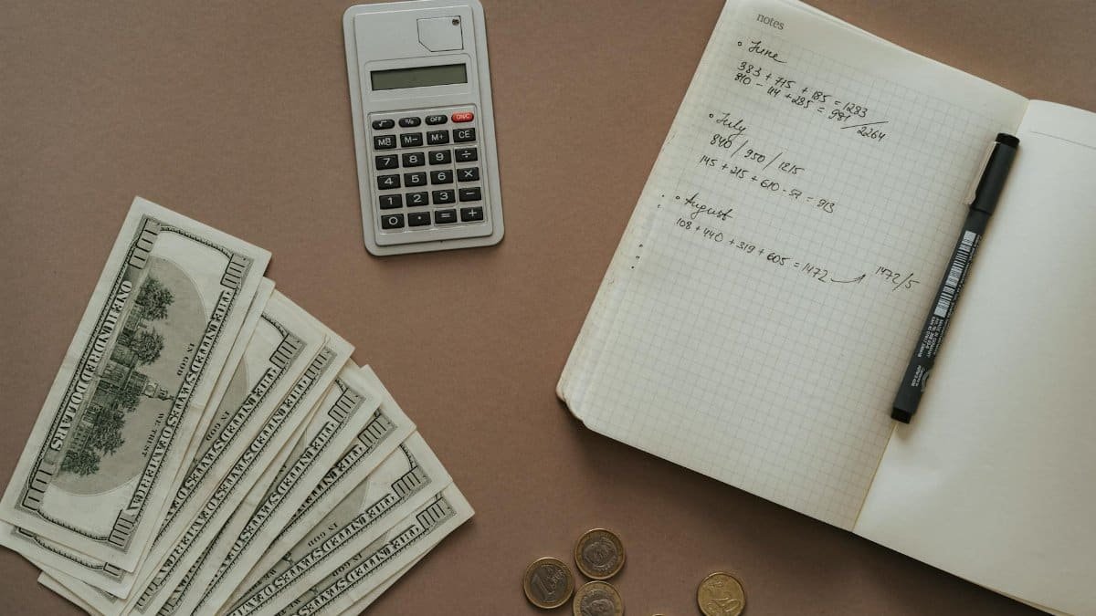 Flat lay with calculator, notebook, and US dollars ideal for financial concepts.