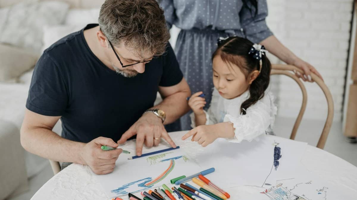 Father and daughter creating art together at home, fostering creativity and connection.