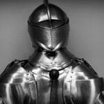 Close-up shot of vintage medieval knight armor in monochrome.