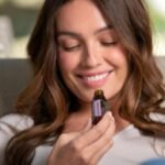 A woman enjoying the aroma of lavender essential oil, promoting relaxation and natural therapy.