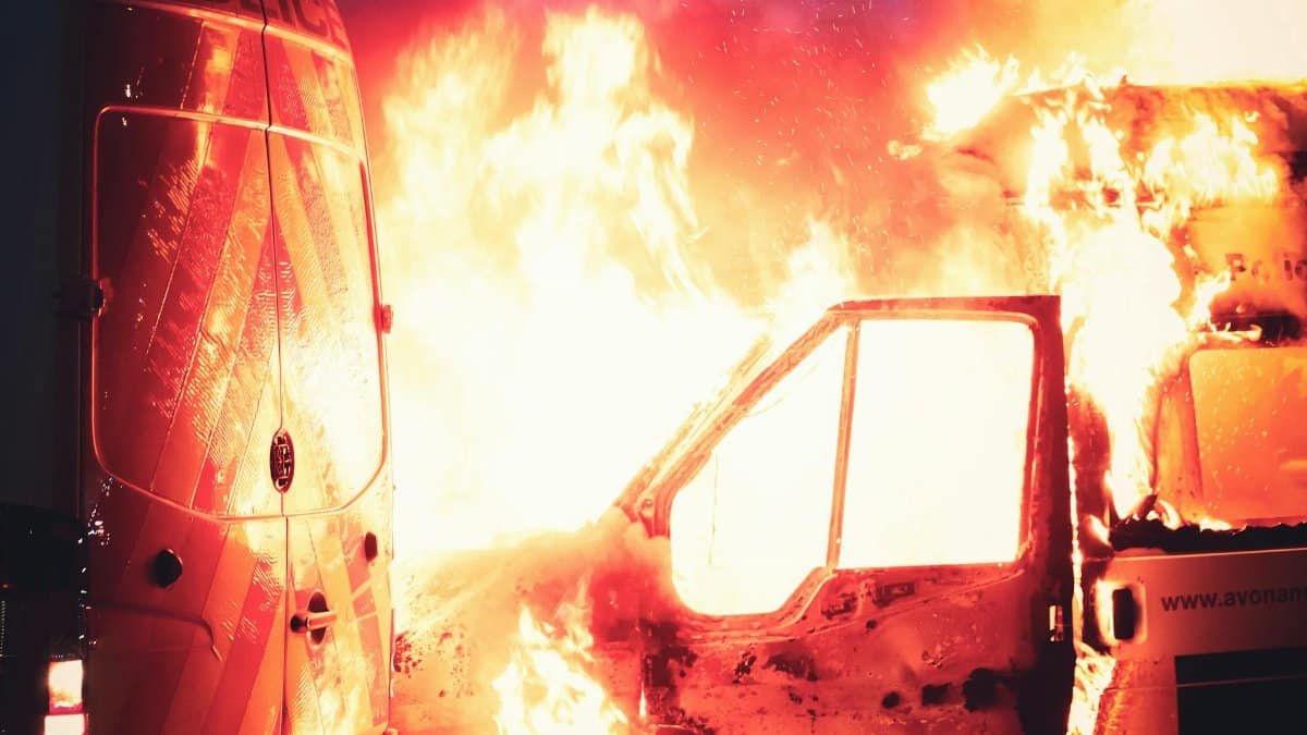 A vehicle engulfed in flames amidst a dramatic scene in Bristol, UK.