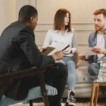 A counseling session with a diverse group of adults discussing issues in a cozy setting.