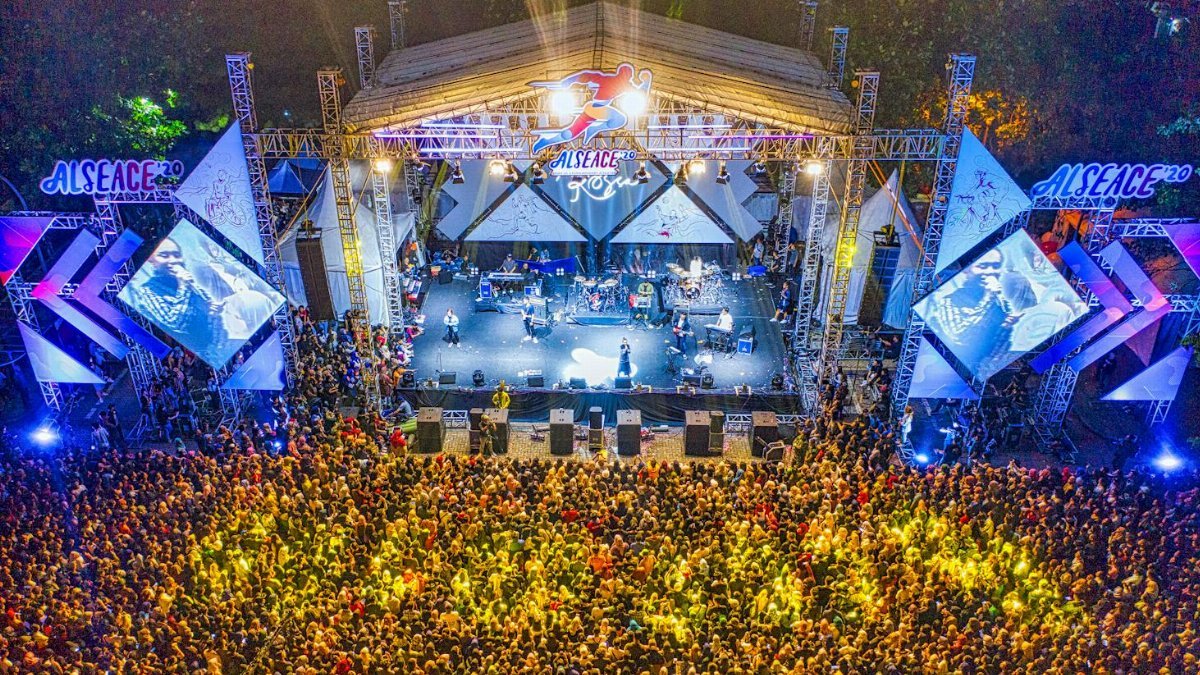 Aerial view of a large crowd enjoying a nighttime concert.