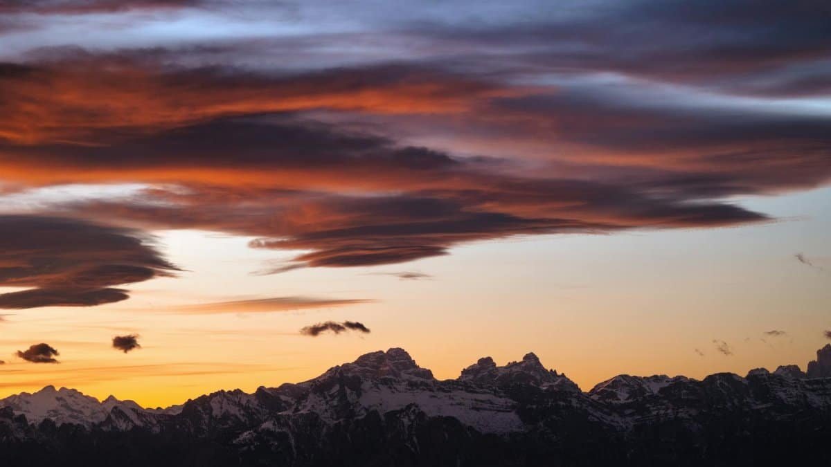 Captivating sunset with dramatic clouds over the Italian Alps showcasing nature's vibrant colors.