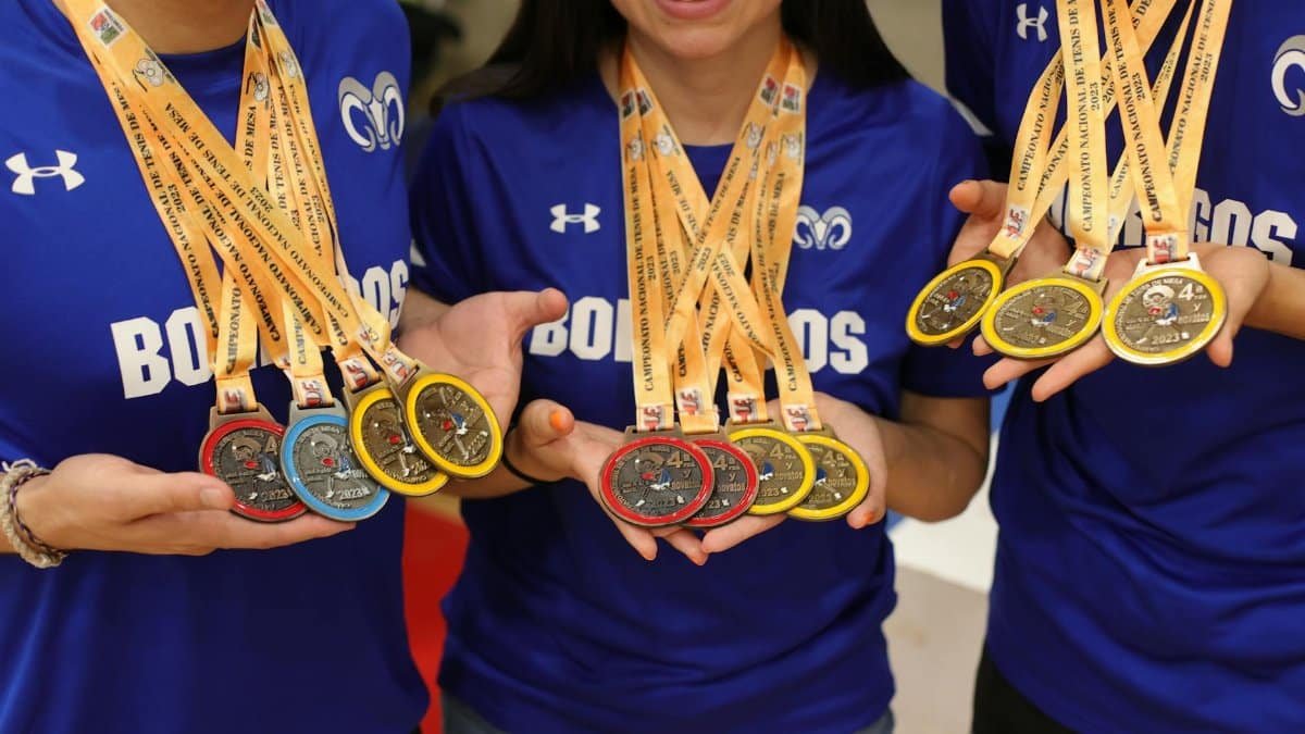 Group of athletes displaying their gold, silver, and bronze medals with pride and joy.