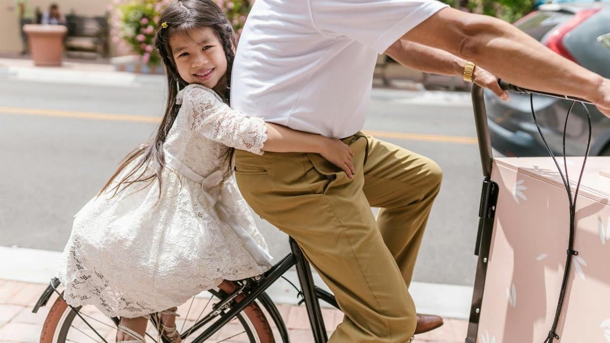 Young girl with long hair enjoys a bicycle ride on a sunny day outdoors.