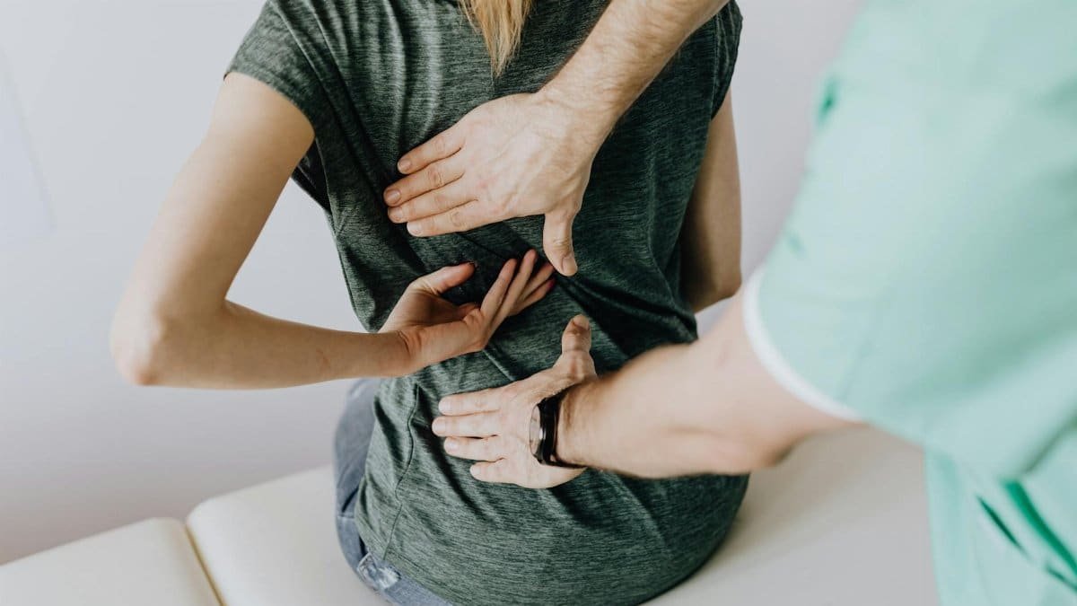 A chiropractor examining a patient's back to alleviate pain and discomfort.