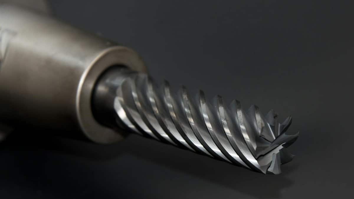 High-quality close-up of a spiral drill bit showcasing metal textures on a black background.