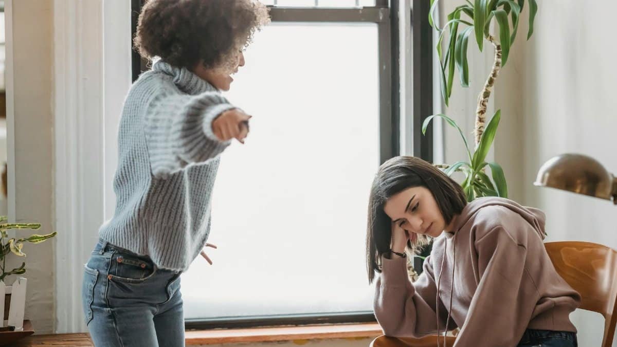 Two women having an intense emotional conversation indoors, involving expressions of frustration.