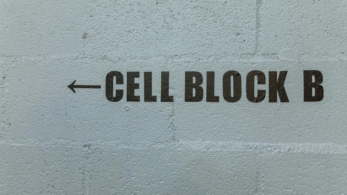 Arrow pointing to Cell Block B on a textured concrete wall.