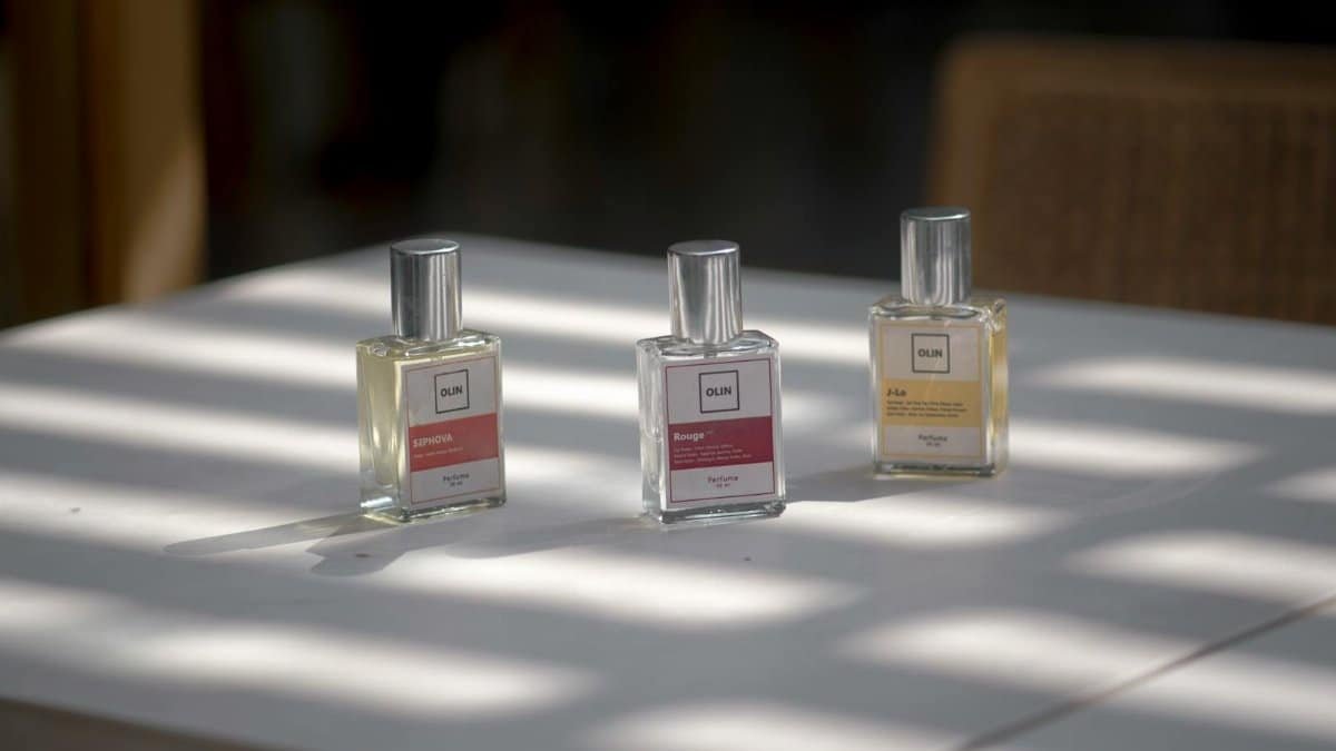 Three elegant perfume bottles arranged on a sunlit table, capturing the essence of fragrance and style.