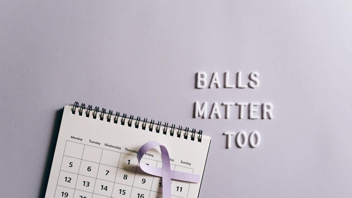 Calendar with ribbon promoting testicular cancer awareness on a light background.