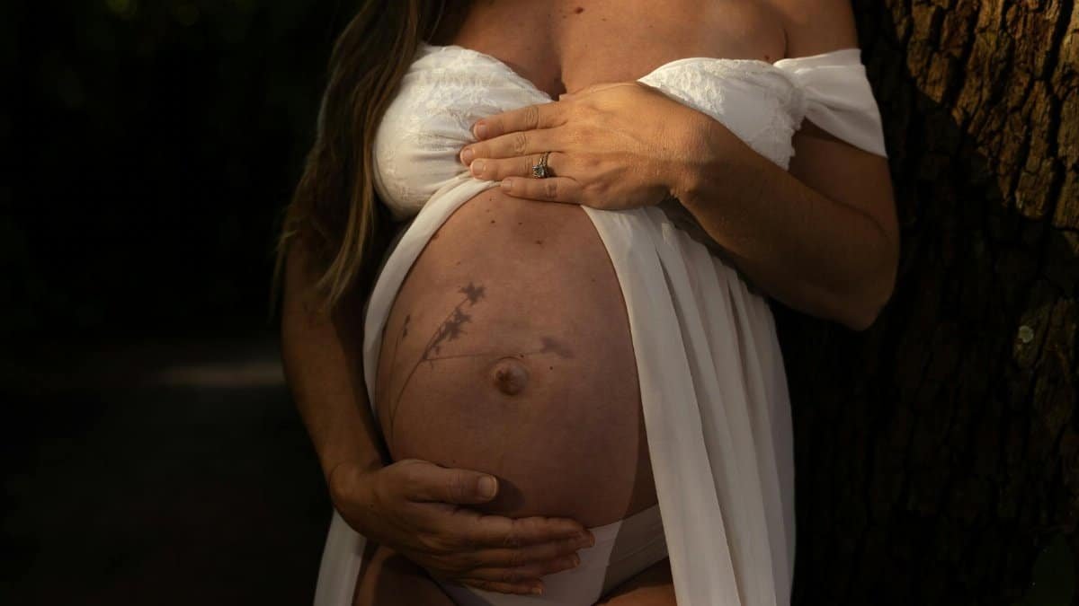 A serene maternity portrait emphasizing the beauty and anticipation of pregnancy in a natural setting.