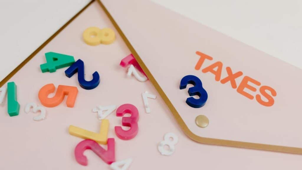 Bright plastic numbers scattered over a tax envelope, symbolizing accounting and finance concepts.