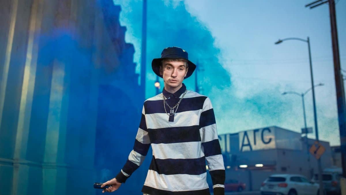 Trendy Gen Z individual with a smoke bomb, showcasing urban street style.