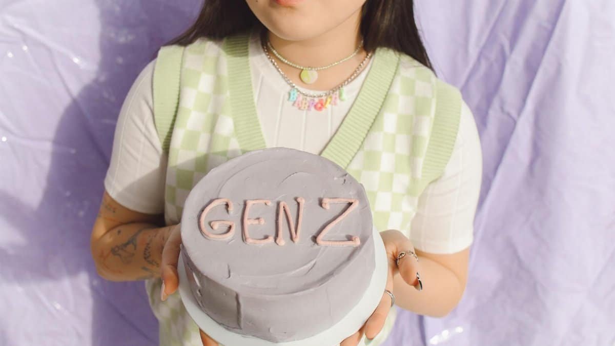 Close-up of a young woman holding a Gen Z themed cake, showcasing modern youth culture.