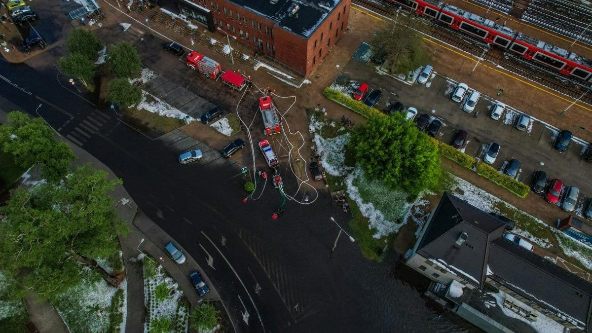 Drone captures emergency response to urban flooding with fire trucks.