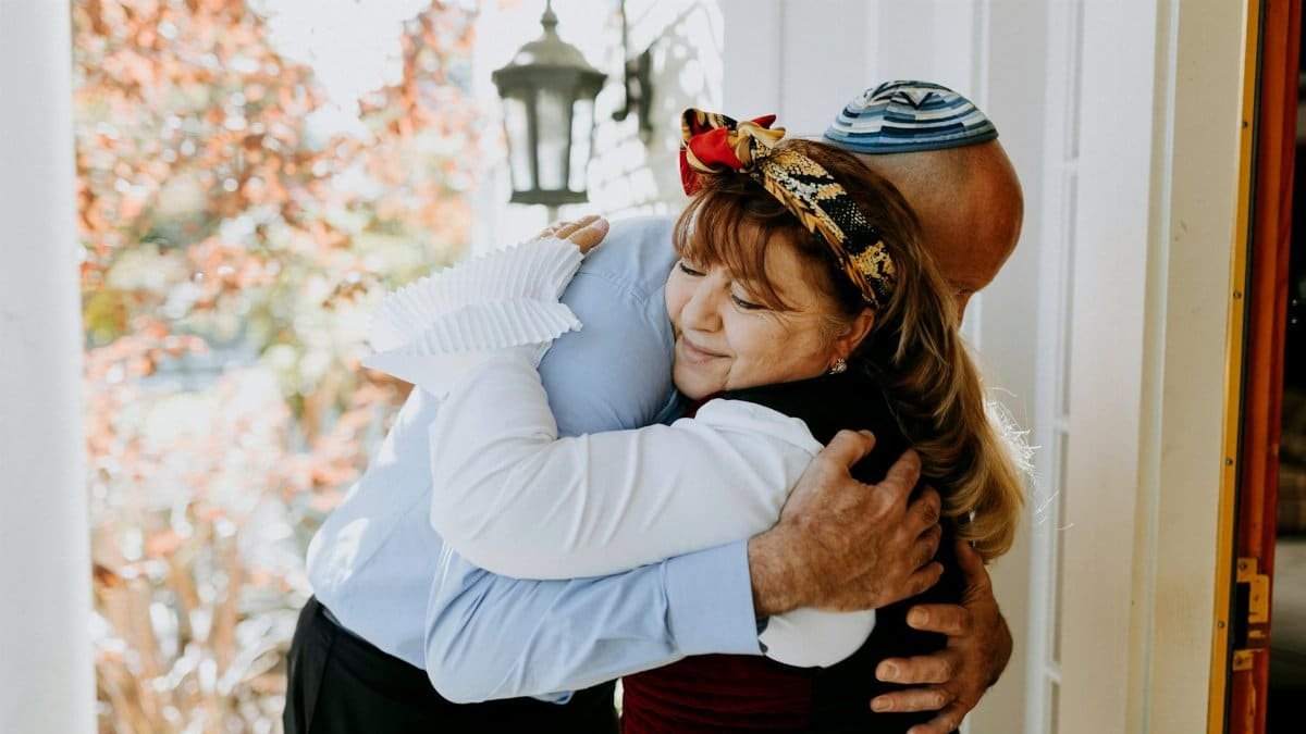 A heartfelt embrace between family members celebrating a Jewish holiday outdoors.