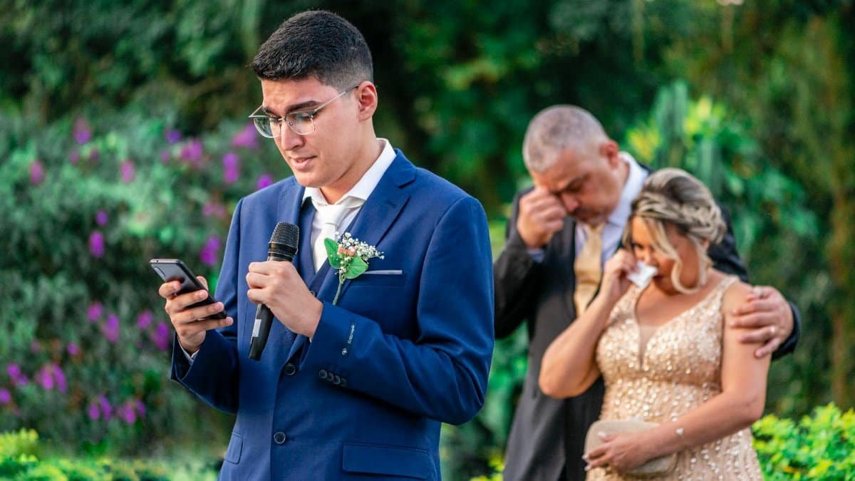 A young man gives a heartfelt speech at an outdoor wedding ceremony.