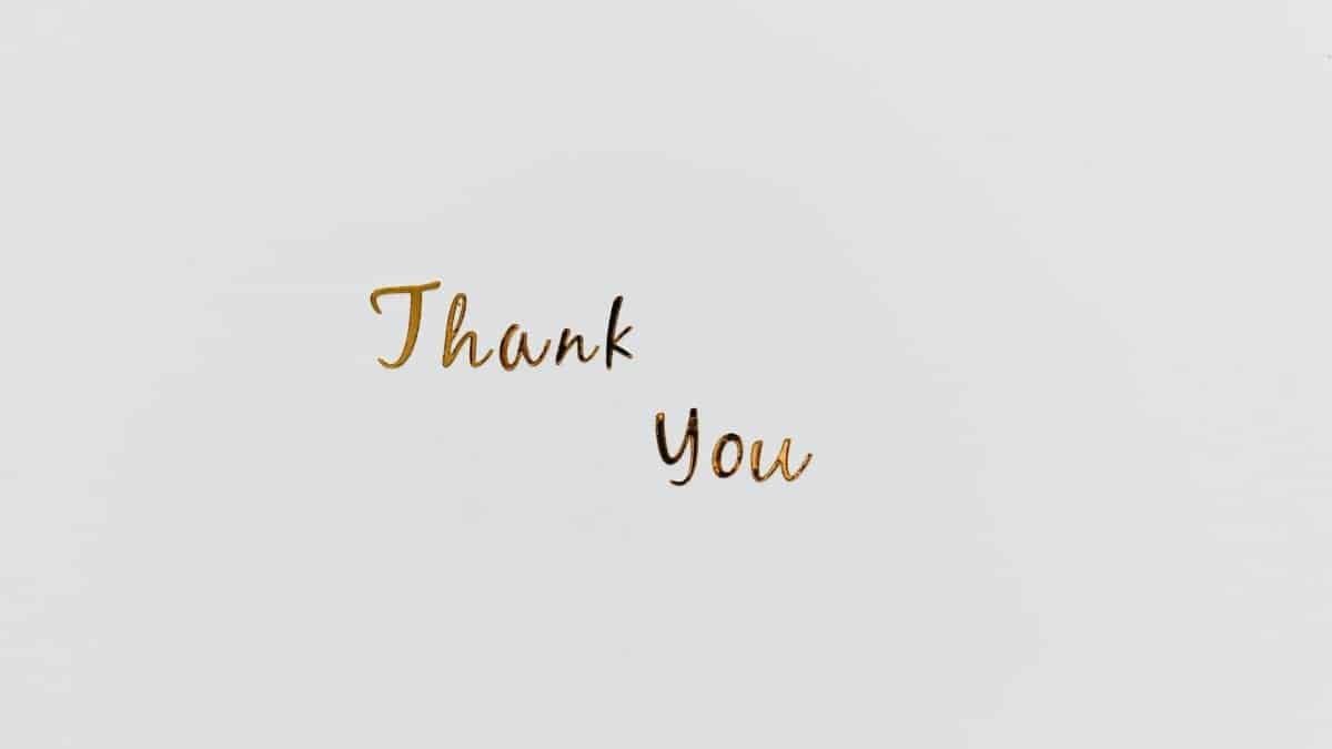 Simple and elegant gold 'Thank You' text on a clean white background, perfect for gratitude cards.