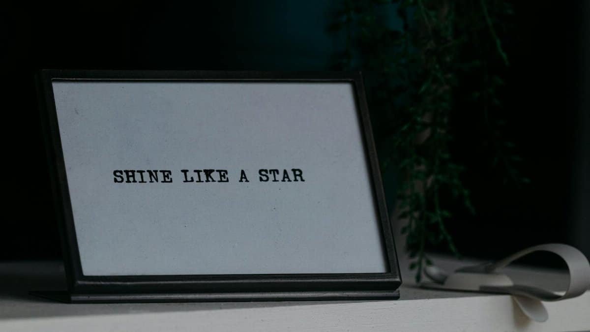 Motivational quote 'Shine Like a Star' in a black frame on a desk.