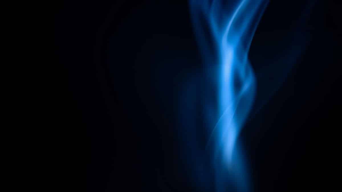 Elegant blue flame against a dark backdrop, creating a mysterious, abstract visual.