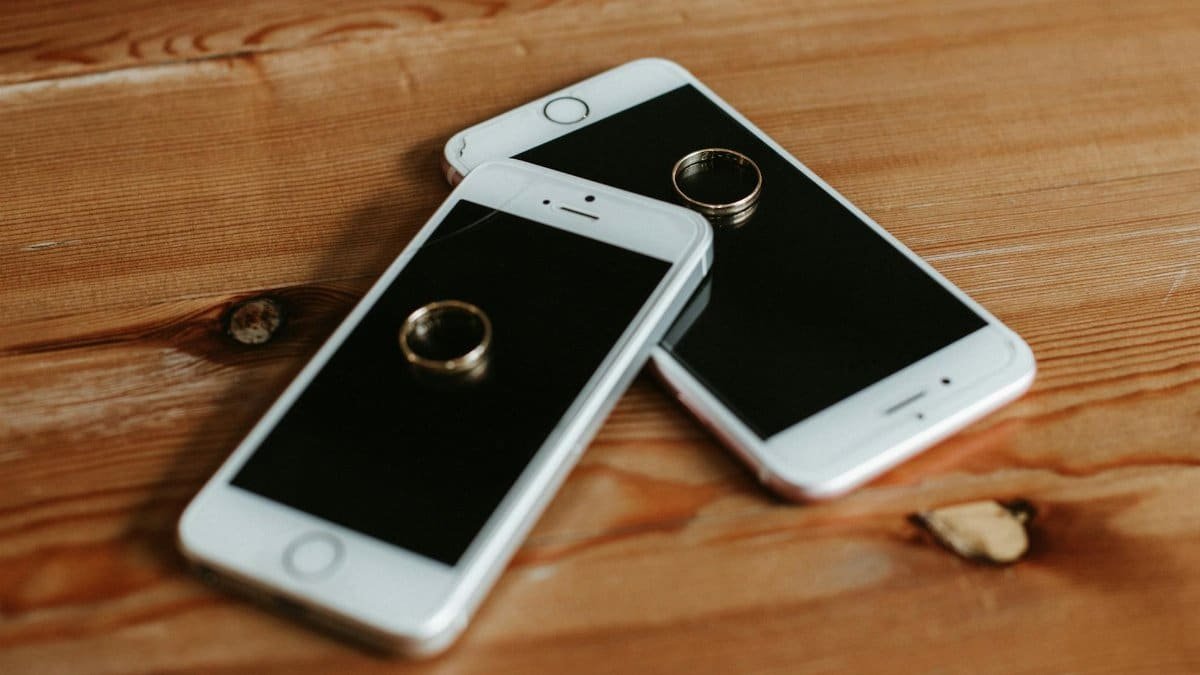 Engagement rings placed on smartphones symbolizing modern connectivity and love.