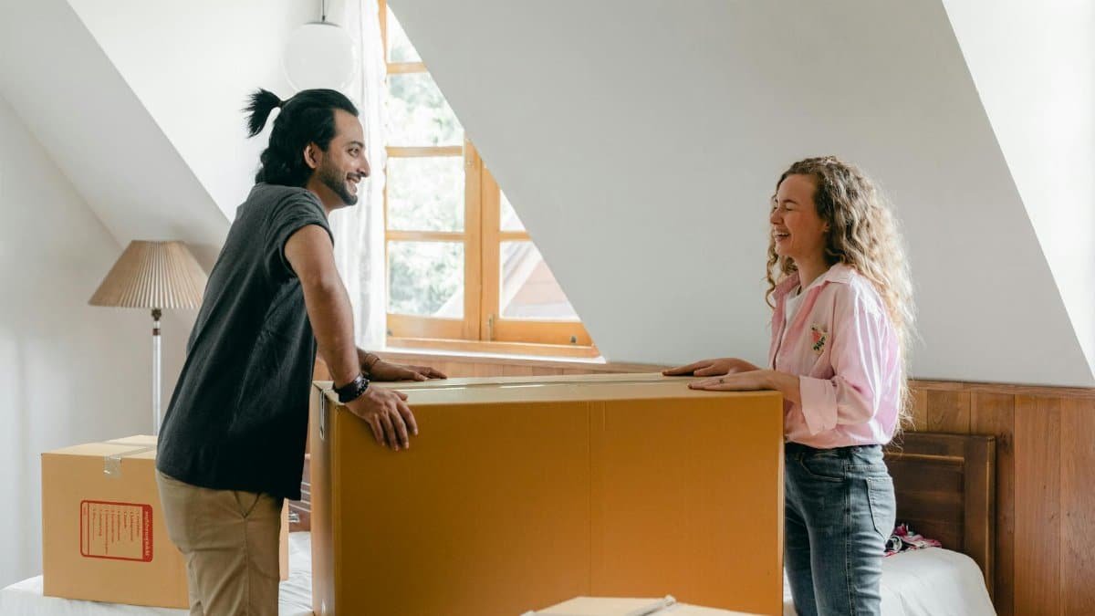 A cheerful couple unpacking boxes in their new apartment, enjoying the moving process.