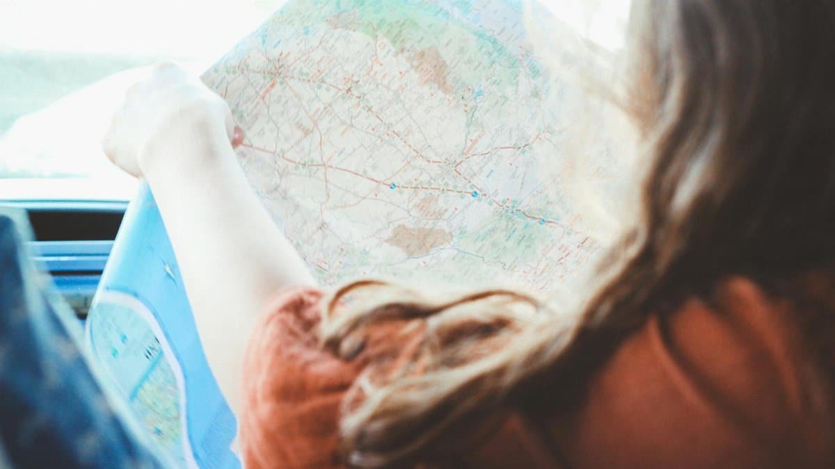 A young woman studies a map, planning her road trip adventure.