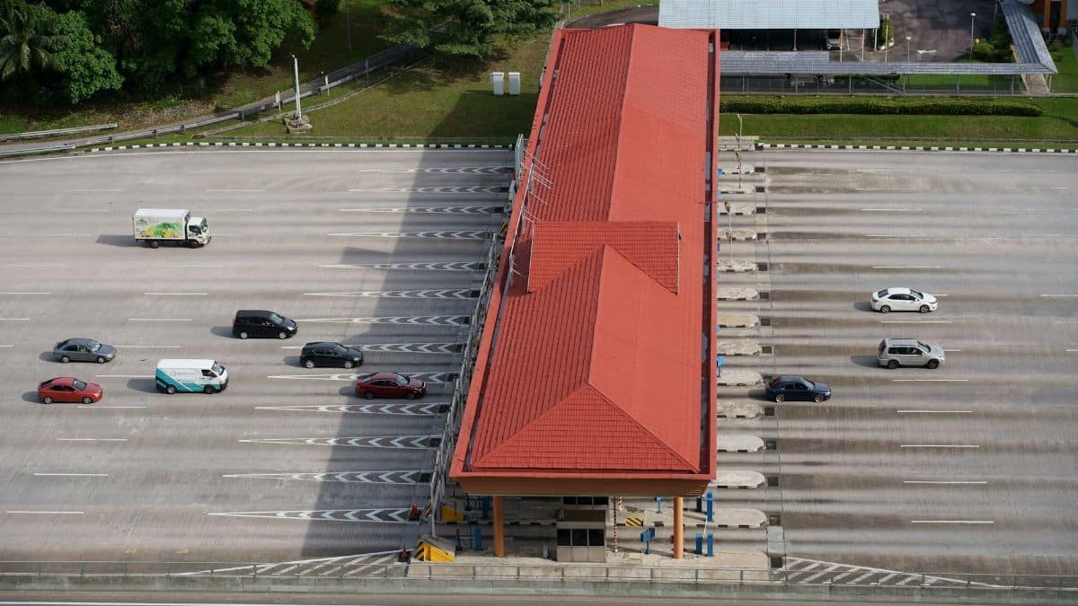 High angle aerial shot of a toll plaza with cars and trucks on an expansive highway.