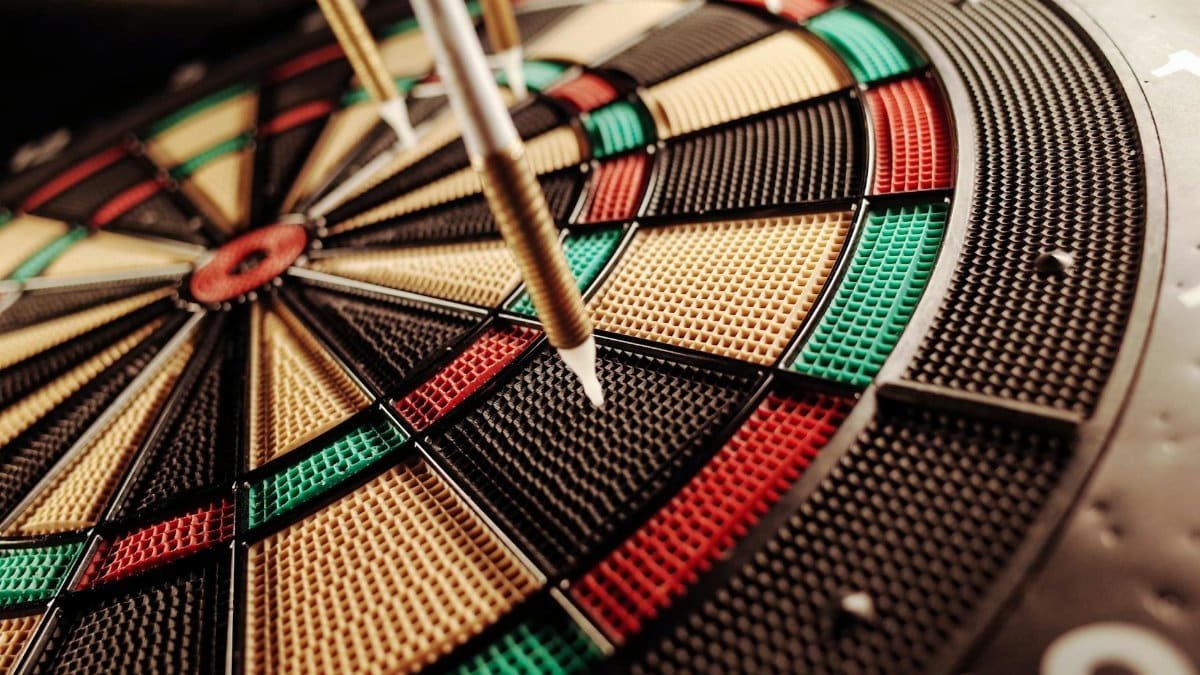 A detailed close-up of an electronic dartboard, showcasing vibrant colors and precision darts hitting the target.