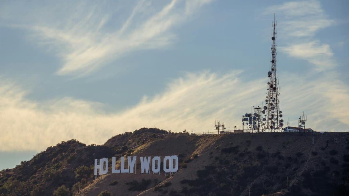 View of the iconic Hollywood sign and cell tower on a sunny day in Los Angeles.
