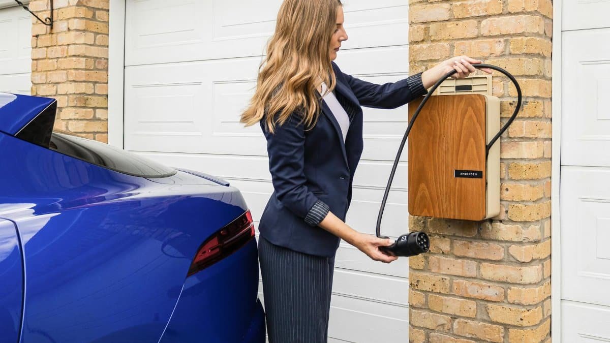 A woman uses a home charging station to charge her electric car, highlighting eco-friendly lifestyle choices.