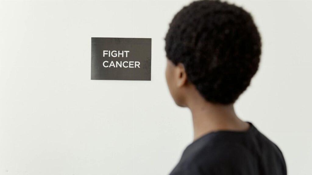 A person looking at a 'Fight Cancer' sign symbolizes cancer awareness.