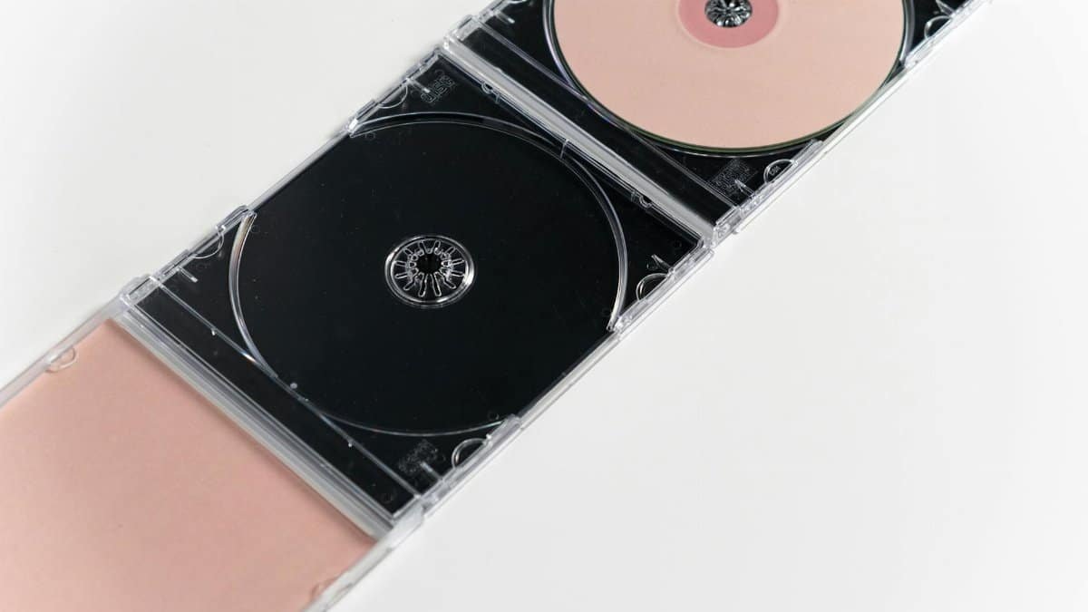 Artistic flat lay of open CD cases on a white surface, showcasing compact discs.