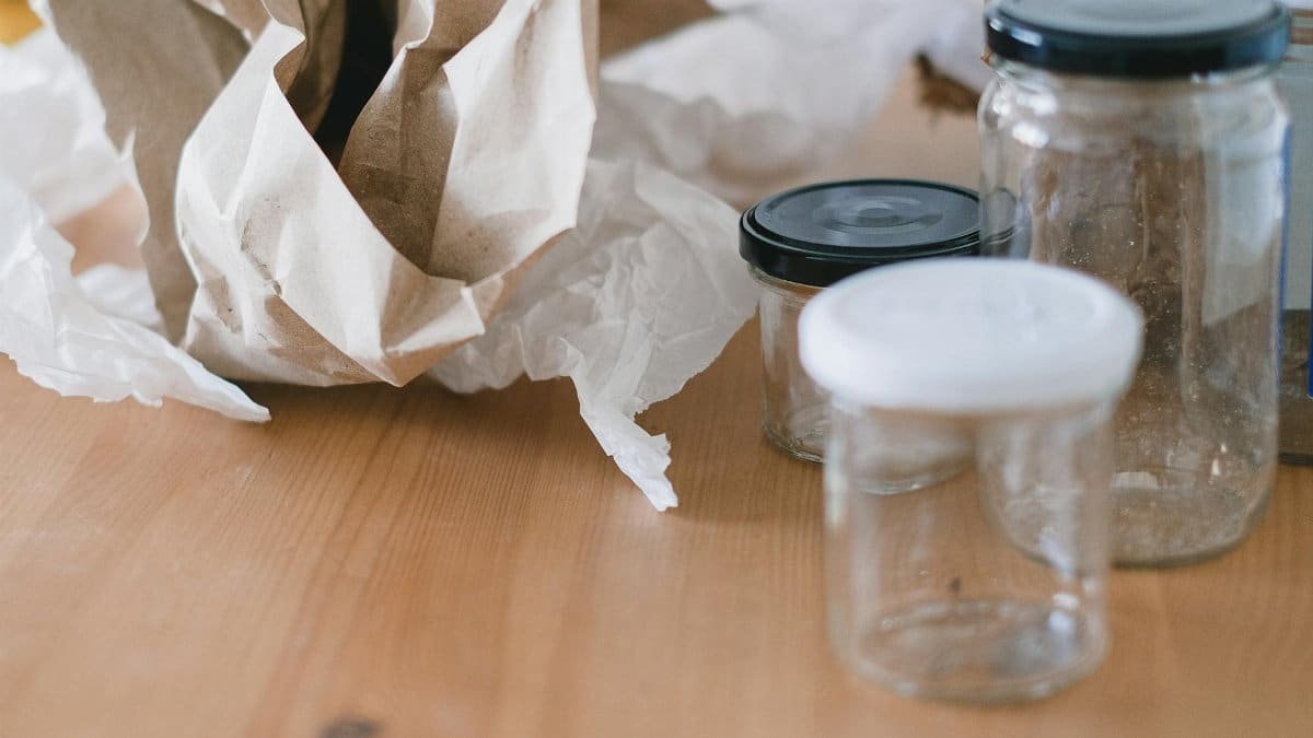 Glass jars and paper for eco-conscious waste sorting. Promote recycling and sustainability.