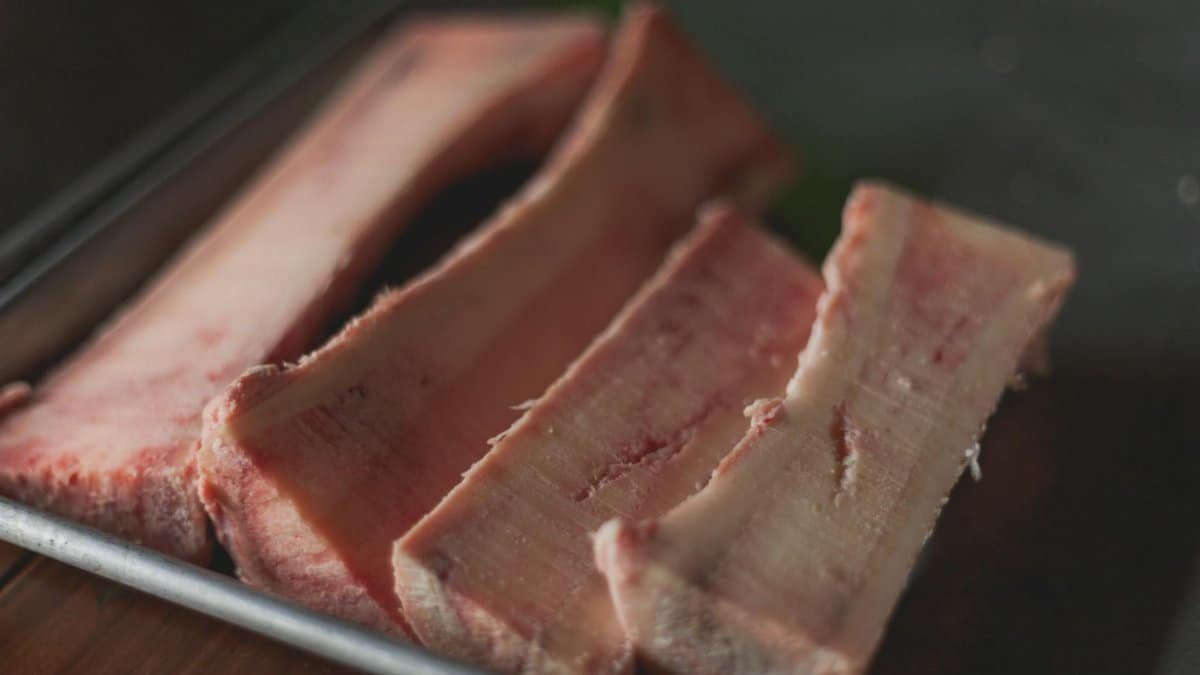 High-quality close-up image of raw beef bone marrow slices on a tray, perfect for cooking concepts.