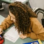 A college student studying for an exam with a smartphone hidden in a pencil case.