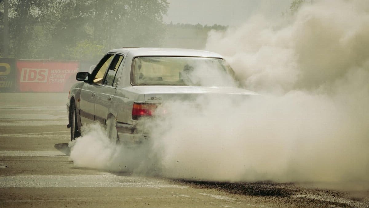 Car performing a thrilling burnout, creating thick smoke at an outdoor location in Izhevsk, Russia.