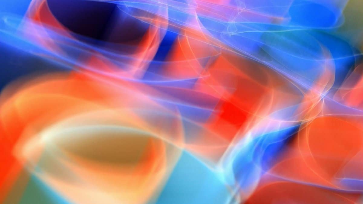 Colorful abstract photo with vibrant light streaks in blue, red, and orange tones.