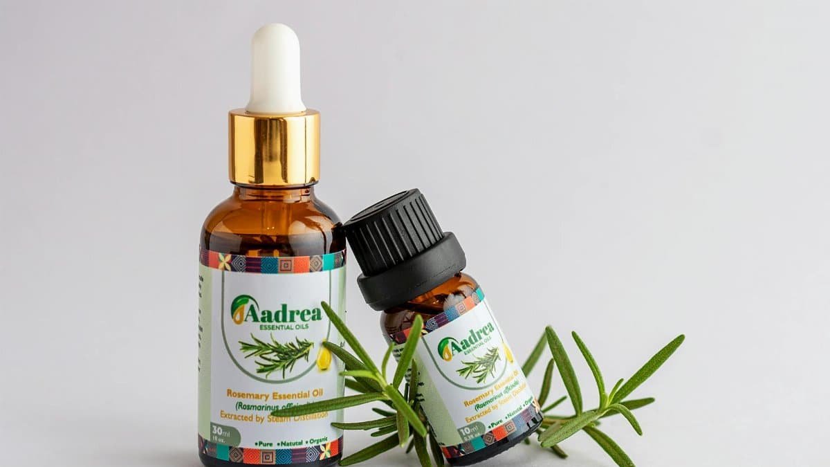 Close-up of rosemary essential oil bottles with fresh rosemary sprig, offering natural aromatic healing.