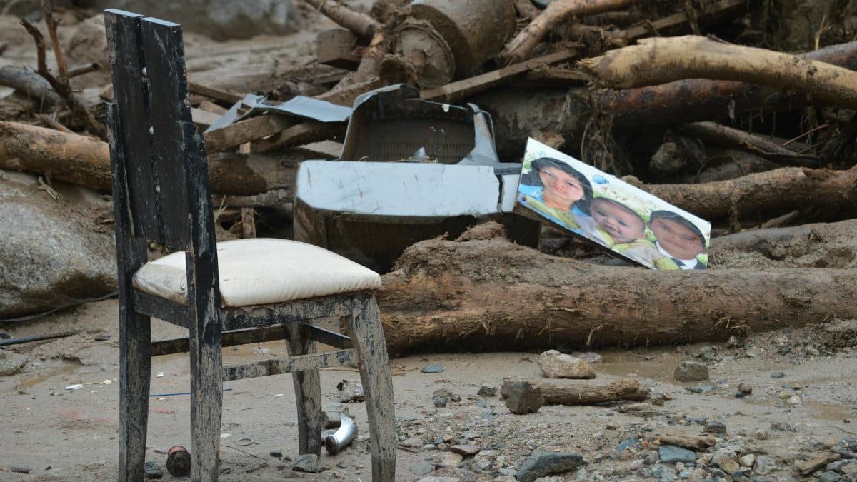 Destruction in Mocoa, Colombia shows a damaged chair amidst debris and rubble, highlighting natural disaster's impact.