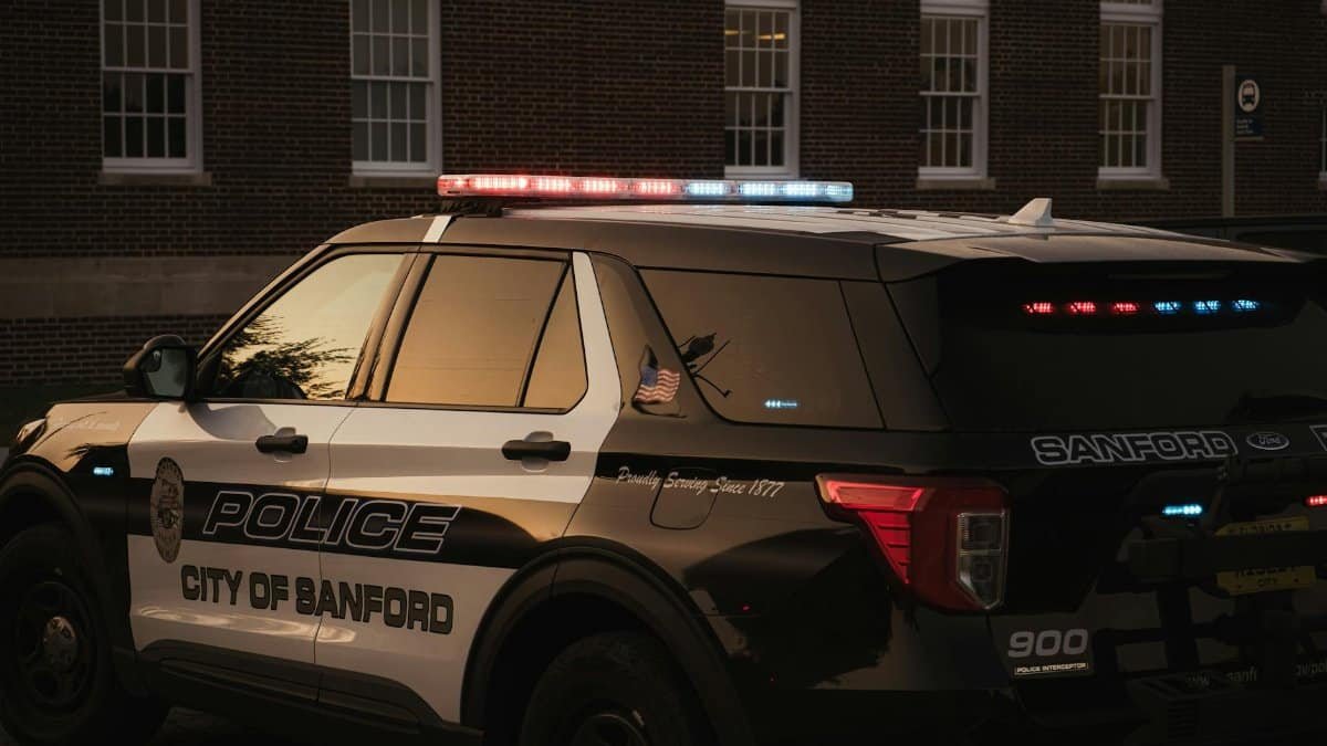 Sanford police vehicle parked outdoors at twilight, showcasing red and blue lights.