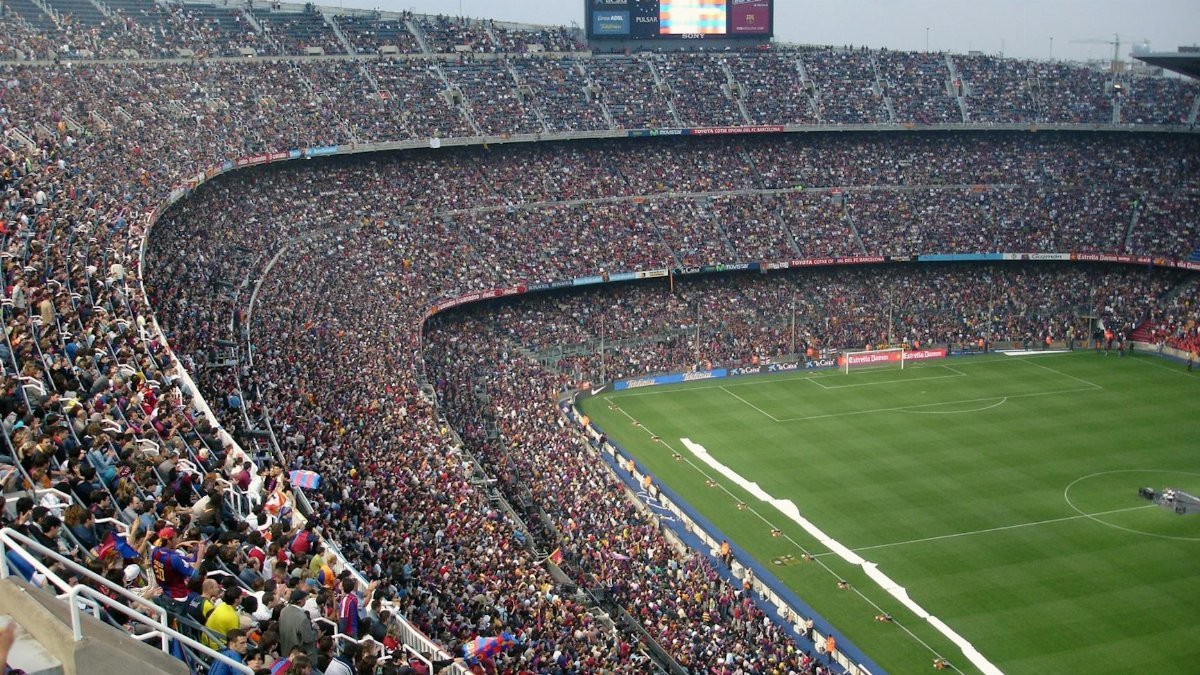 A packed stadium with enthusiastic fans watching an exciting soccer match.
