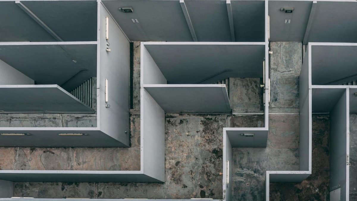 Aerial view of a complex indoor labyrinth made of concrete walls.