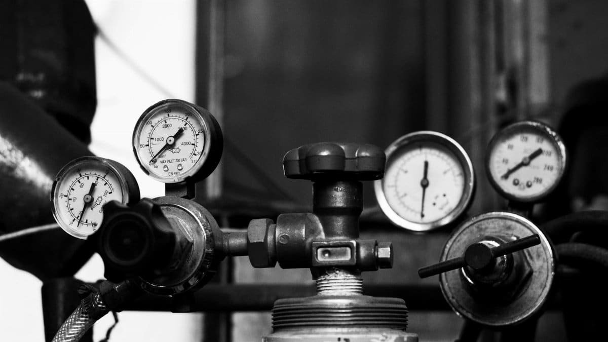 Black and white photo of vintage industrial pressure gauges and valves displaying precision mechanics.