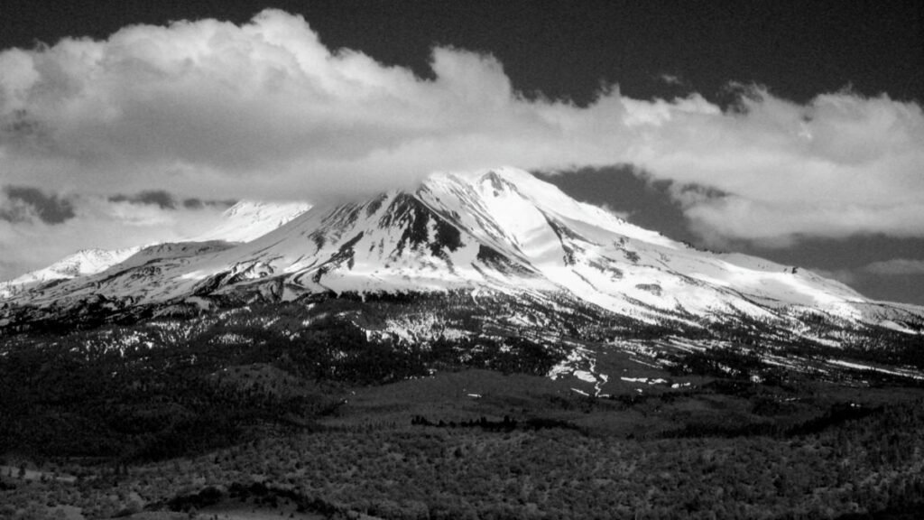 Black and white photo of Mount Shasta in California, showcasing its dramatic snow-capped peak.