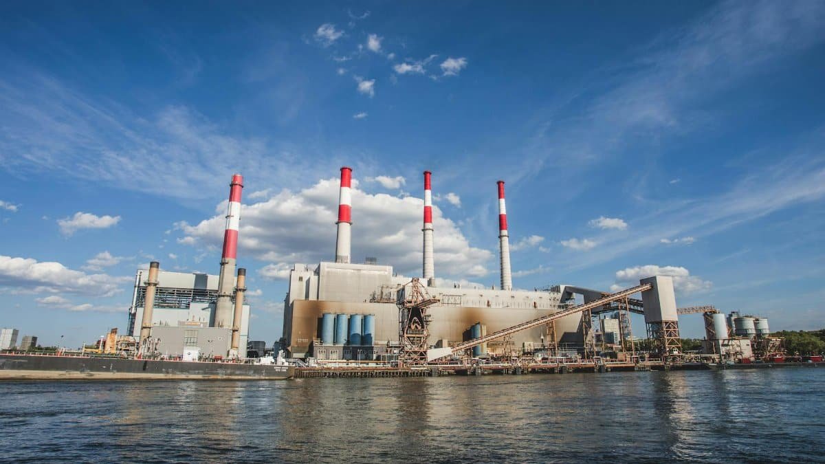 A wide view of Ravenswood Generating Station with chimneys and waterfront in New York City.