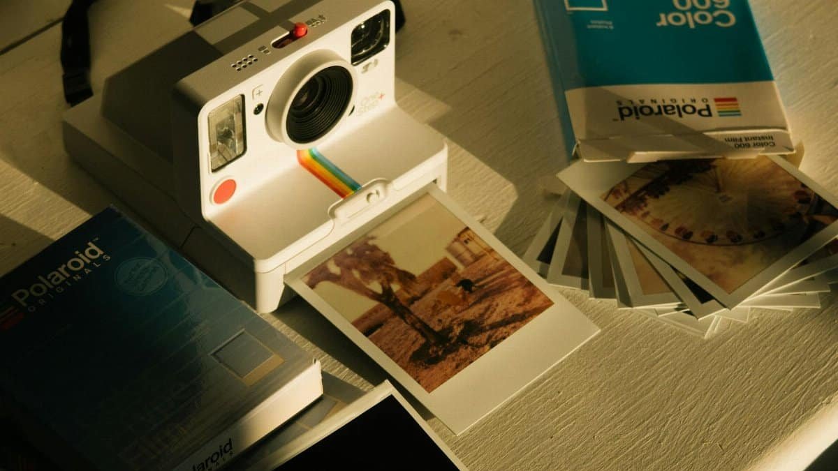 Vintage-style photo setup with instant camera and Polaroid prints emphasizing nostalgic appeal.