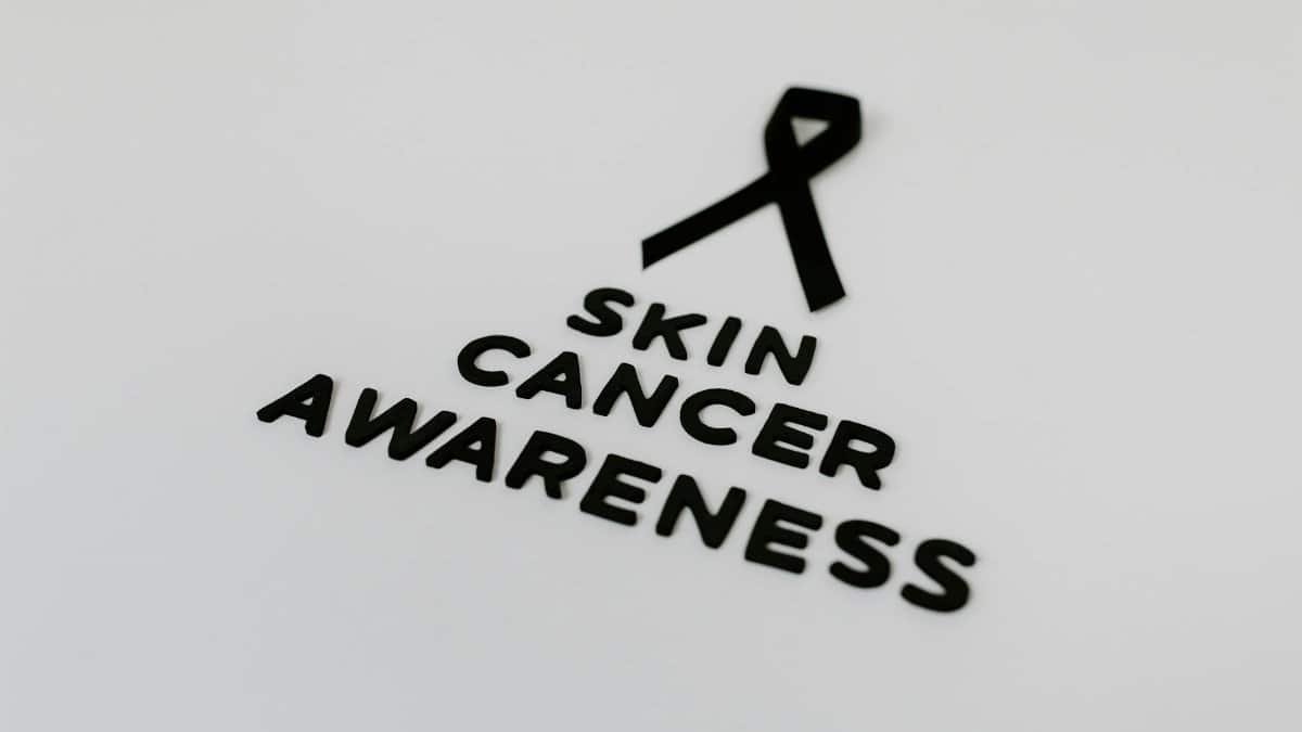 Black ribbon symbolizing skin cancer awareness on a white background.